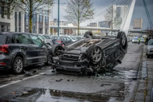 Auto slaat over de kop na aanrijding met geparkeerde auto in Rotterdam